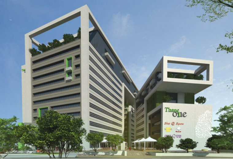 Exterior view of the modern multi-story Redbrick Offices, Thane One building with green accents and landscaped trees.