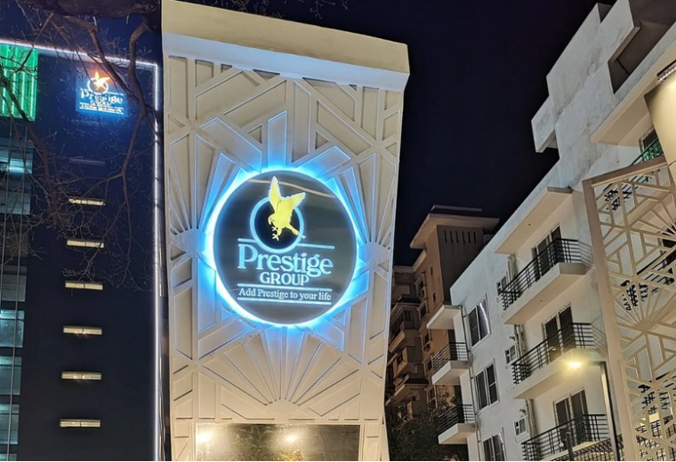 Exterior view of Prestige Summit building at night with illuminated signage.