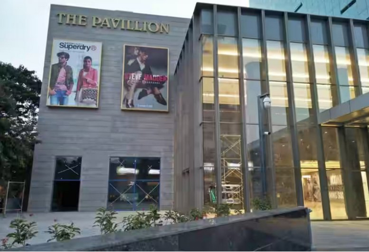 Entrance of The Pavillion with large storefront windows and advertising banners.