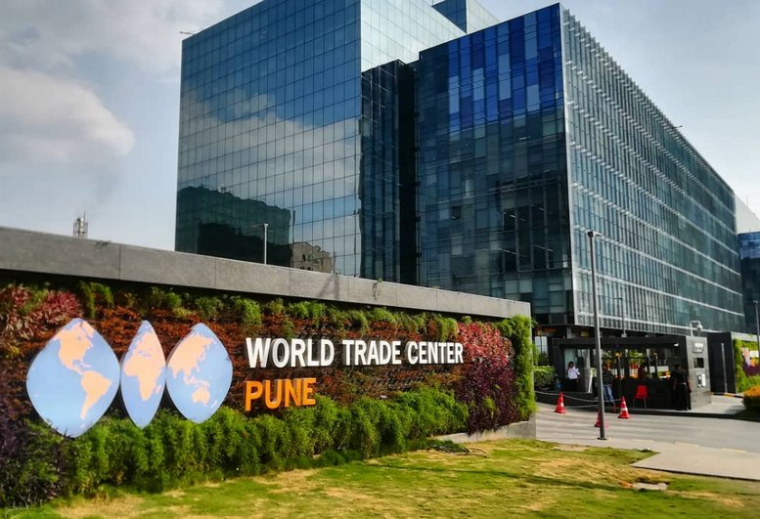 Exterior view of the Redbrick Offices, World Trade Centre, Kharadi with a green living wall and globe logo.