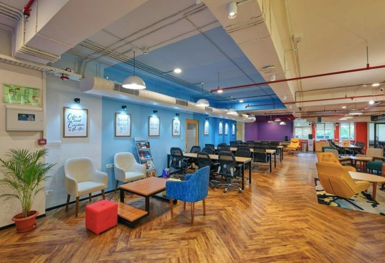 Spacious communal lounge at Shubharam Complex,144, Mahatma Gandhi Road with colorful seating and herringbone floors.
