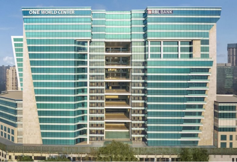 Symmetrical exterior view of the teal glass One World Center with central balcony cut-outs.