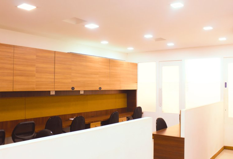 Open-plan workspace with wooden cabinetry and yellow backsplash at Vascon Platinum Square.