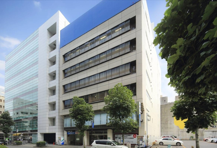 Exterior view of the contemporary Yagihyo Tenmacho Building featuring a blue facade accent and glass windows.