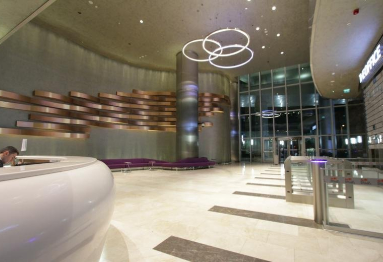 Spacious reception lobby at Mall of İstanbul with a curved desk and modern ring light fixtures.