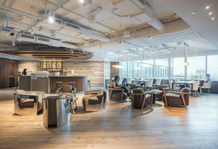 Spacious communal lounge and reception area at the PCCW Tower with wooden floors and city views.