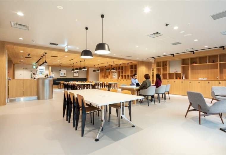 Spacious communal lounge with wooden accents and modern pendant lighting.