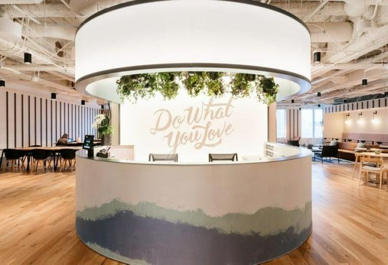 Reception area at 55 Seocho-daero 77-gil featuring a curved desk with mural and hanging plants.