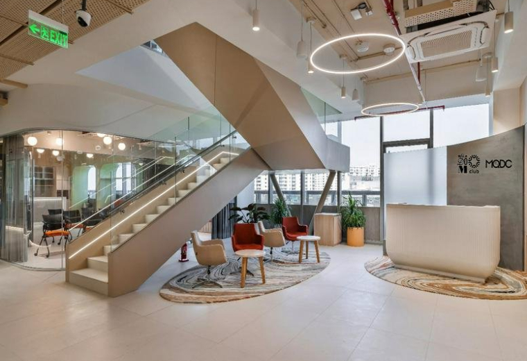 Spacious reception area and lobby at 4th Floor, Tapasya One featuring a grand staircase and modern lounge seating.