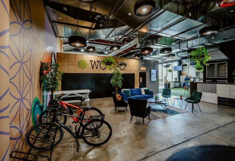 Spacious communal lounge at WOTSO Chermside featuring bicycles, blue sofas, and industrial ceiling details.