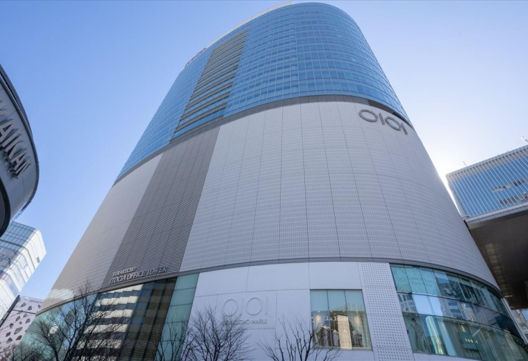 Exterior view of the curved glass and stone facade of the Yurakucho Building.