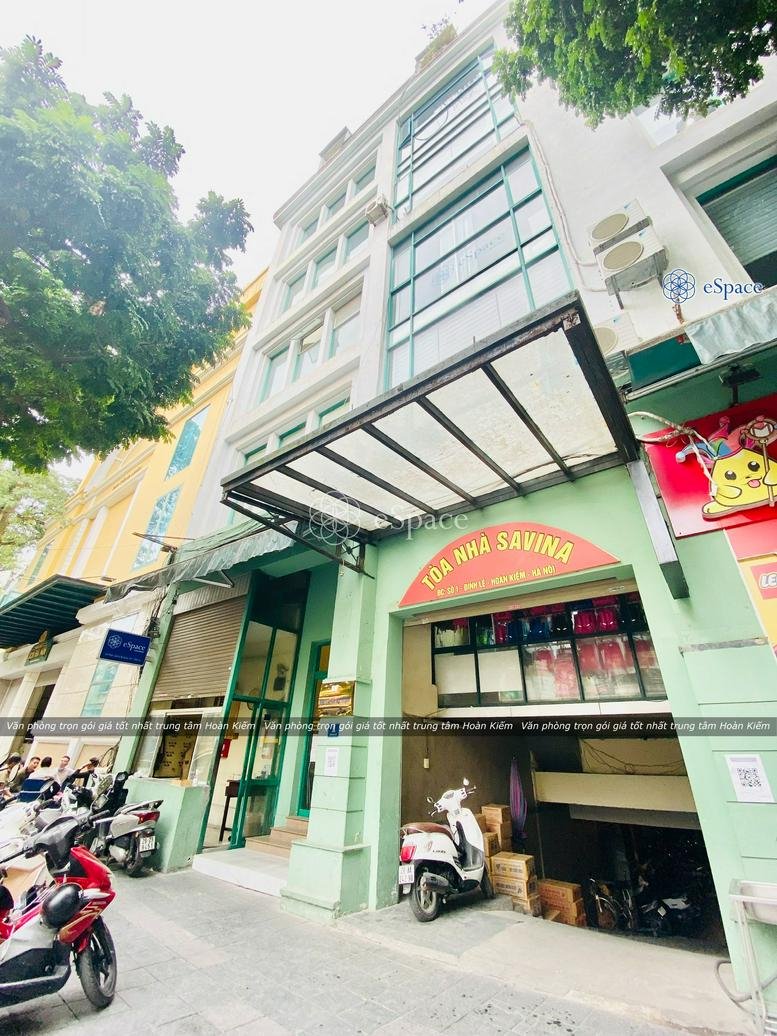 Exterior view of Tòa Nhà Savina with a modern facade and street-level entrance.