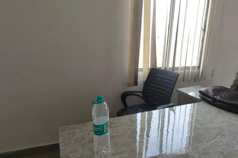 Spacious workspace at Anantham Building featuring a marble-top desk and black ergonomic chair.