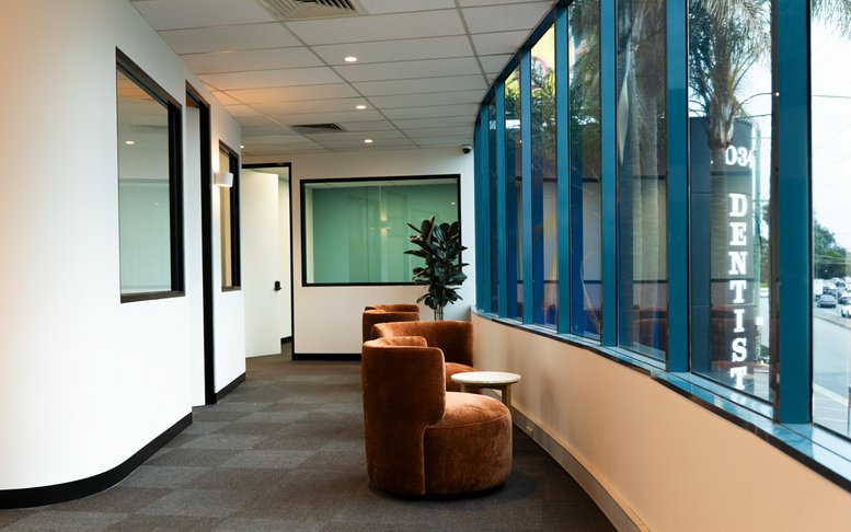 Spacious reception area at 1044A, Dandenong Road, Carnegie with brown velvet armchairs and large windows.