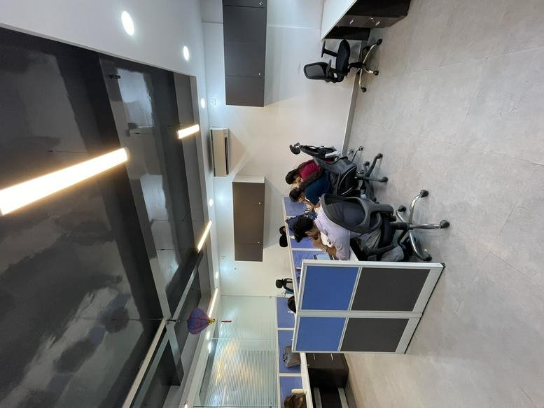 Spacious open-plan workspace at Indraprakash Building with modern workstations and sleek ceiling lighting.