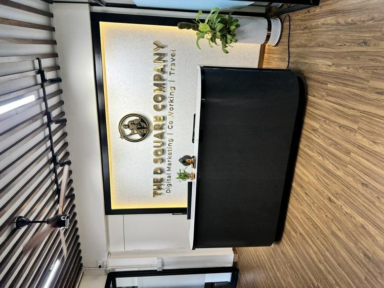 Branded reception area at 139, 5th Main Rd, 6th sector, HSR Layout, featuring a black desk and wooden floors.