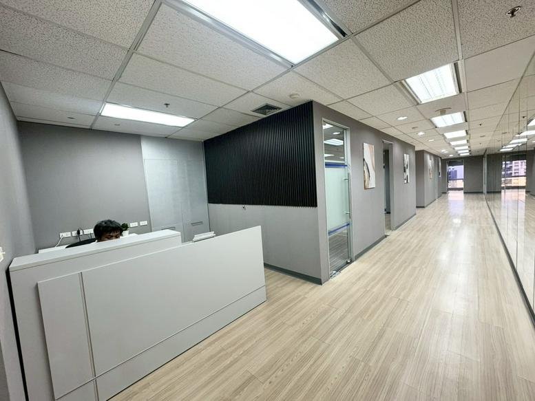 Modern reception area at 159, Sukhumvit 21 Road with a white front desk and grey feature walls.