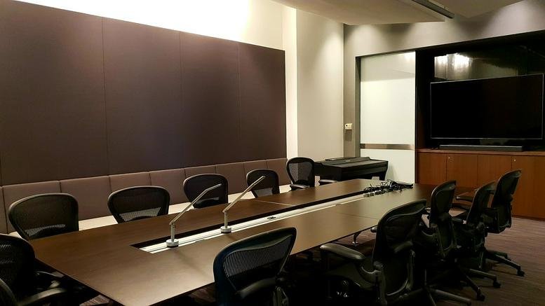 Large professional meeting room at 18 Boon Lay Way #02-105 with a long dark wood table and several mesh chairs.