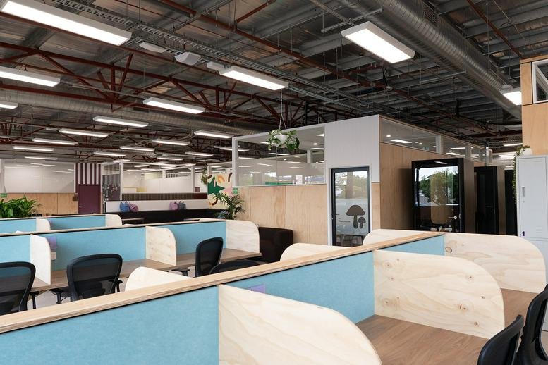 Spacious open-plan workspace at 182 Monash Drive, Dandenong South featuring modern blue and wood-panelled cubicles.