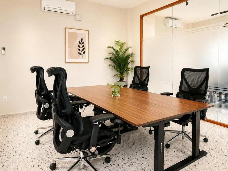 Meeting room with a long wood table and black ergonomic chairs at 191, Đường Nguyễn Thái Bình, Ben Thanh Ward.