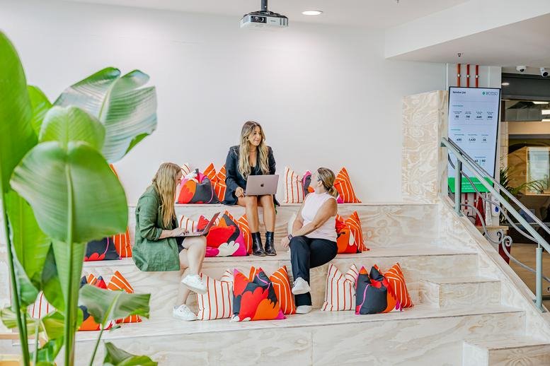 Bright tiered communal seating area with orange cushions and plants at 22, Giffnock Avenue, Macquarie Park.
