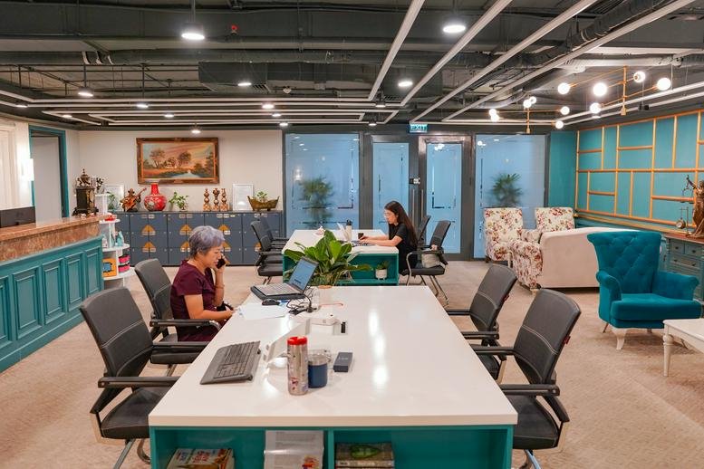 Spacious coworking area with white desks, teal cabinetry, and colorful armchairs at 25, Phố Lý Thường Kiệt, Cửa Nam.