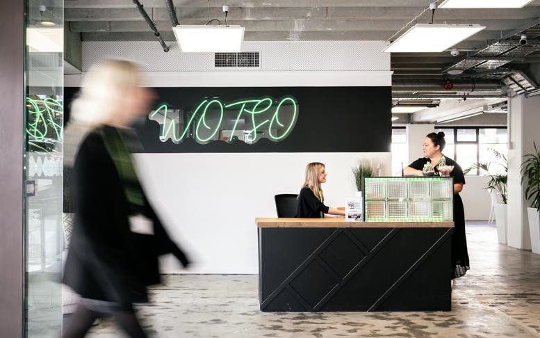 Reception area at 271, Willis Street with a neon logo and a dark textured front desk.