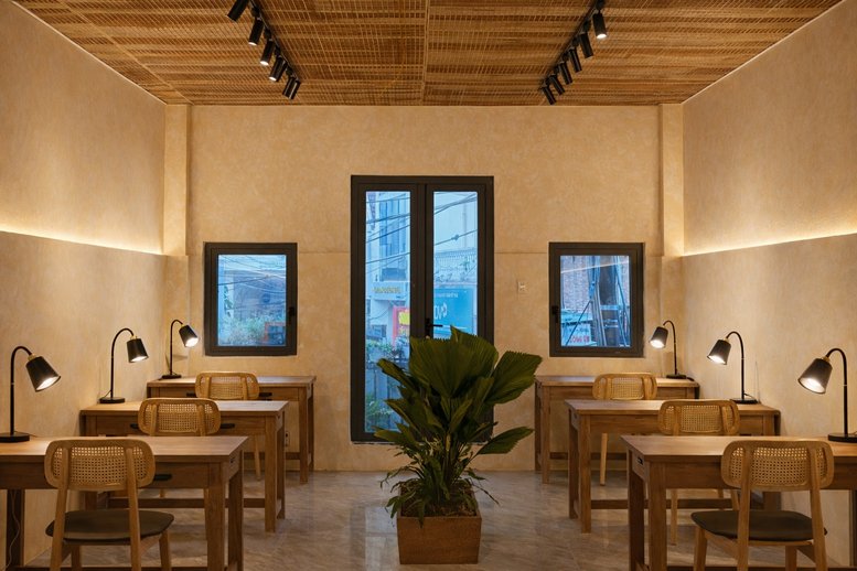 Symmetrical coworking space at 17 Đường Trương Công Định with wooden desks, rattan chairs, and warm lighting.
