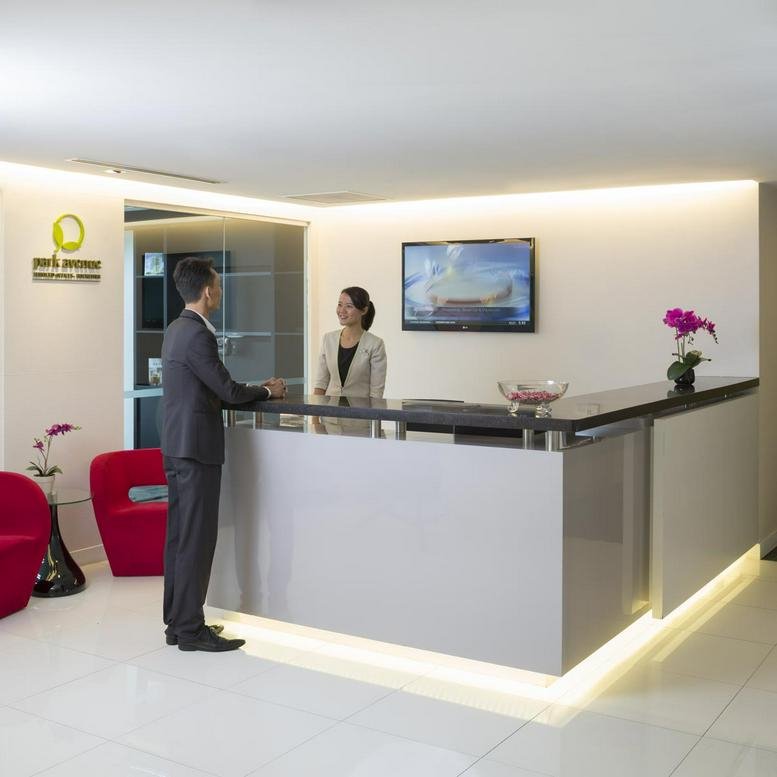 Professional reception area at 31, Rochester Drive with a modern desk and red accent chairs.