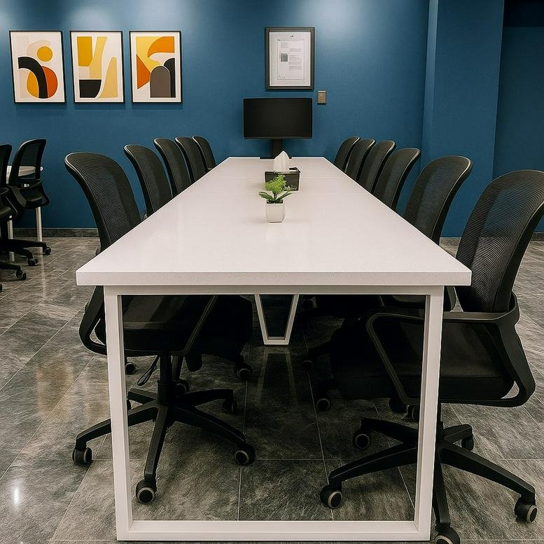 Sleek meeting room with a long white table and a dark blue feature wall.
