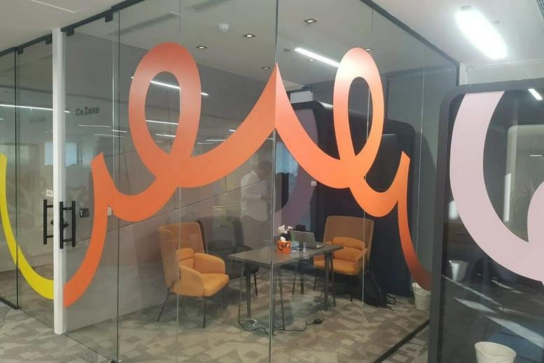 Meeting room with orange wall graphics and armchairs at 3614, الامير مقرن بن عبدالعزيز.