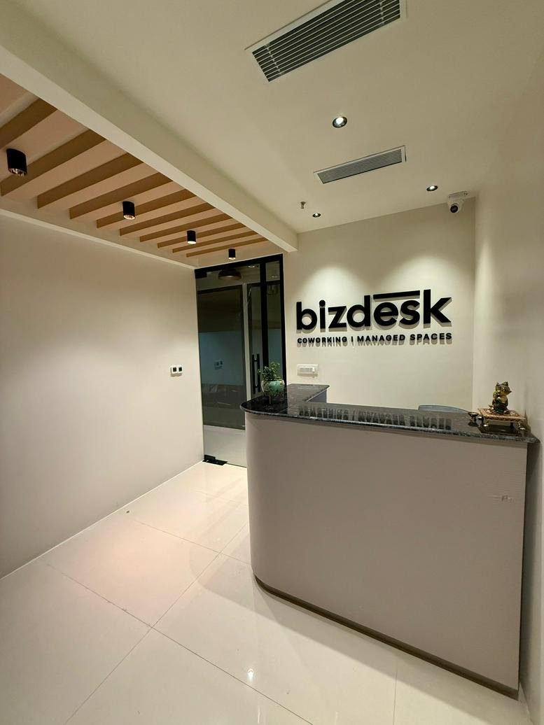 Modern reception area at Iridium, Shalimar Corporate Park with a minimalist front desk and wood-slat ceiling.