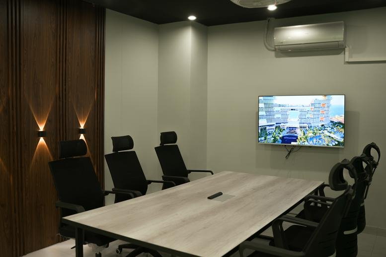 Modern conference room at 43 L, Johar Town with a wooden feature wall and wall-mounted TV.