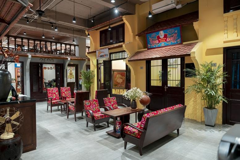 Spacious communal lounge at 44, Tràng Tiền, Hoàn Kiếm with vibrant red seating and traditional architectural details.