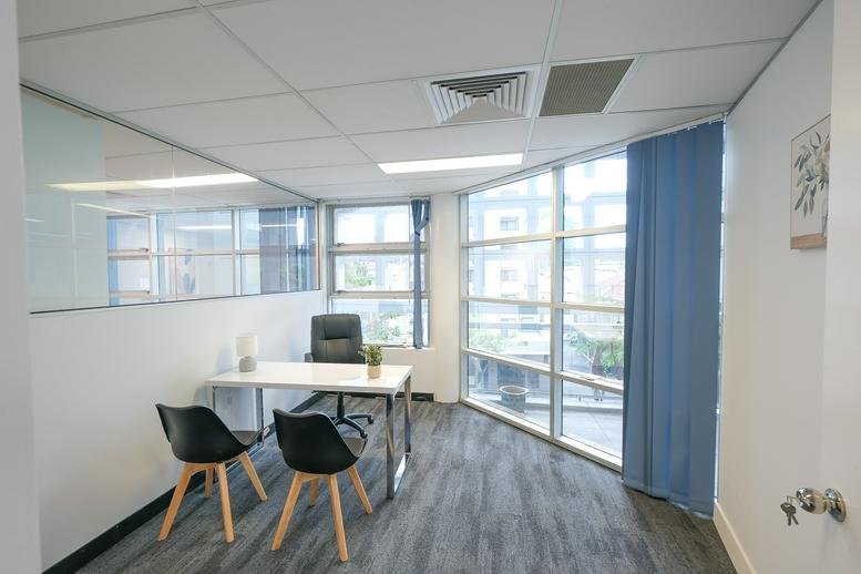 Balcony view of Upper Edward Street with modern glass façade and city skyscrapers.