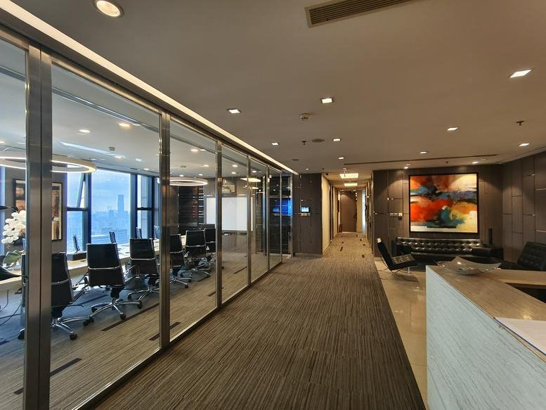 Modern reception lobby with glass partitions and a view into a professional boardroom.