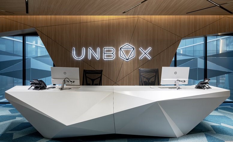 Futuristic white geometric reception desk at 4th Floor, with wood-paneled feature wall and logo.