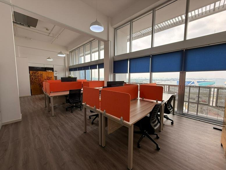 Open-plan office with orange privacy screens and expansive window views.