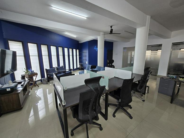 Interior view of a modern open-plan office with sleek design and workstations.