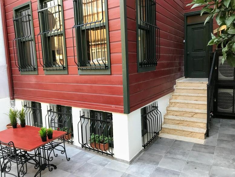 Exterior view of the red wooden facade and entrance at 9, Selamet Sokak, Muratreis Mah. Selamet Sok. No: 9.