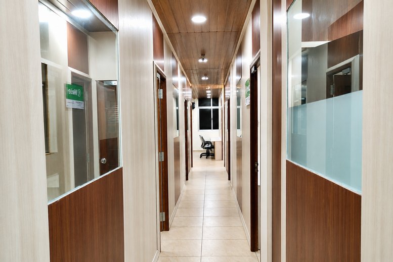 Long hallway at GT-CoWorks featuring wood-paneled ceilings and glass-partitioned office suites.