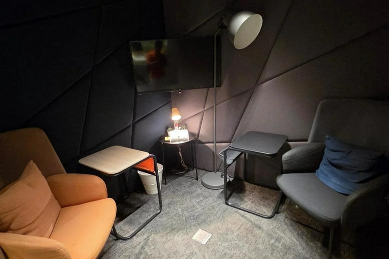 Dimly lit private acoustic booth at Al Andalus Road, Souls Center featuring armchairs and a wall-mounted TV.