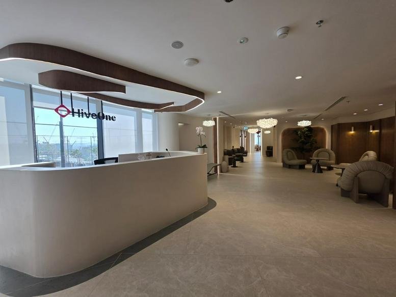 Welcoming reception area with curved white desk and logo.