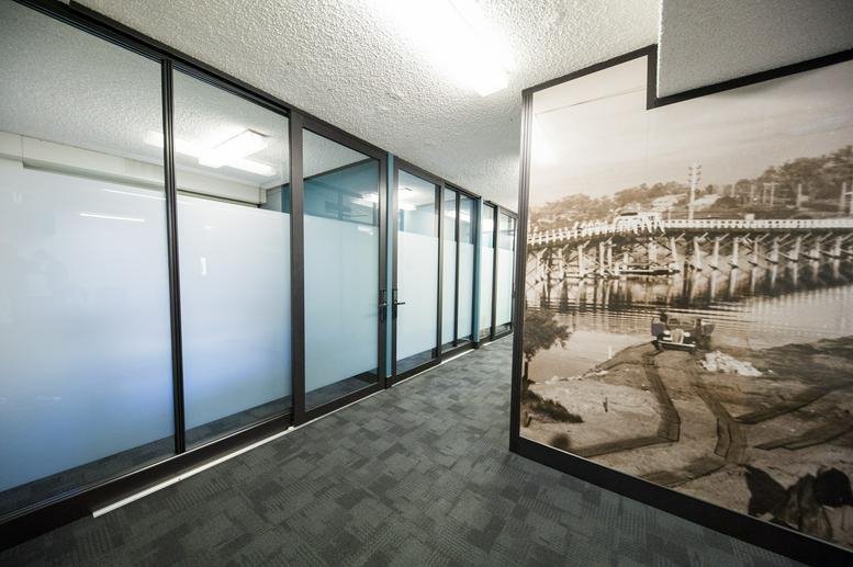 Modern corridor at 1/896 Canning Highway with glass-walled offices and a large monochrome historical mural.