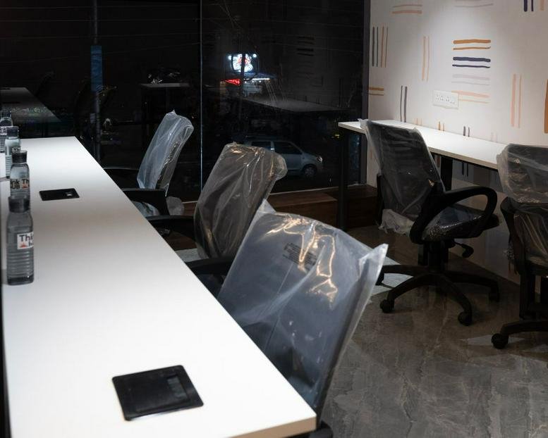 Workspace with private desk cubicles and plastic-wrapped chairs at 11, Manewada Road, Nagpur.