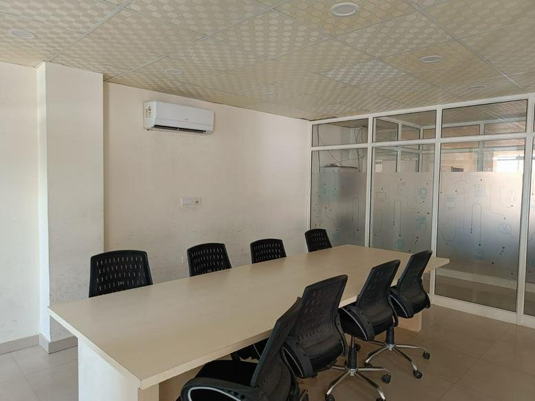 Meeting room at 12, Shiv Marg, Kirti Nagar, Shyam Nagar, Jaipur with white table and black chairs.