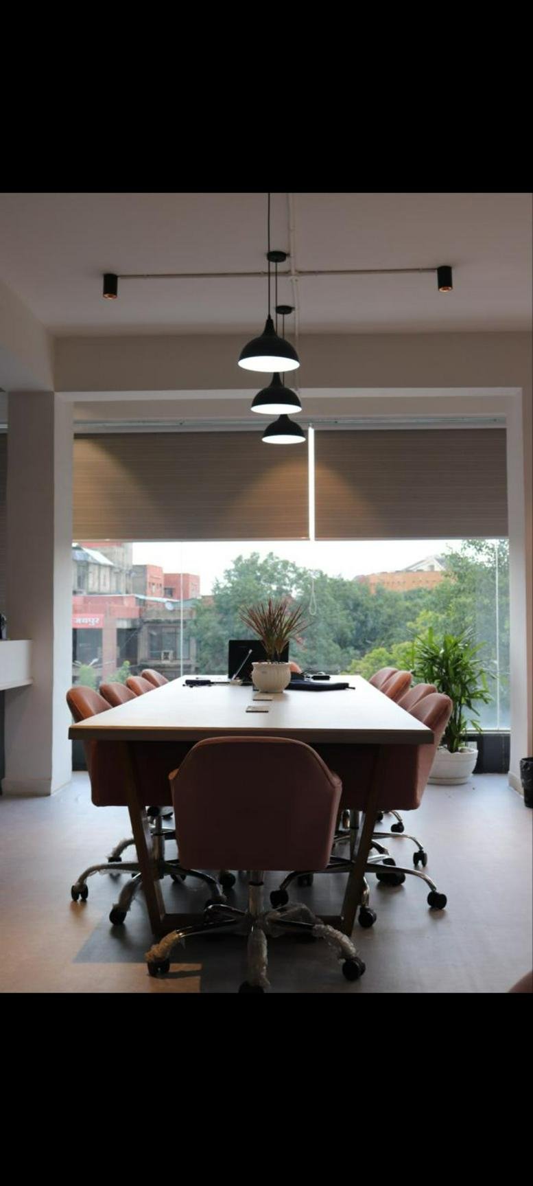 Modern conference room at 12, Shiv Marg, Kirti Nagar, Shyam Nagar, Jaipur with pendant lighting and city views.
