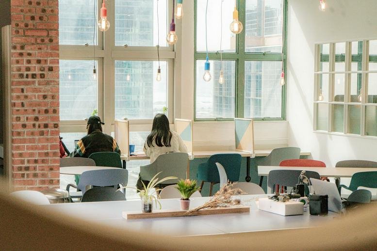 Spacious coworking lounge with hanging Edison bulbs and natural light at Entrepot Centre.