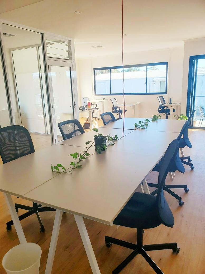 Spacious coworking space at 2/10 Towers Drive with a long shared desk and ergonomic chairs.