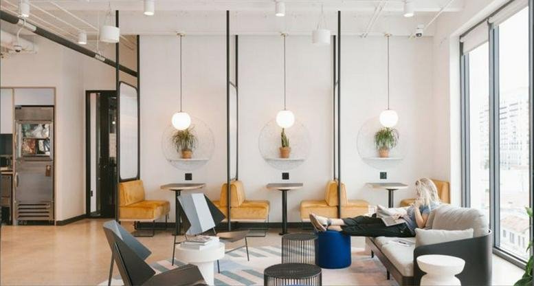 Bright breakout lounge at 2 Chome-11-15 Kanda Jimbocho with yellow velvet armchairs and hanging pendant lights.